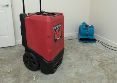 2 different types of drying fans, set up in bedroom to remove moisture from the floor