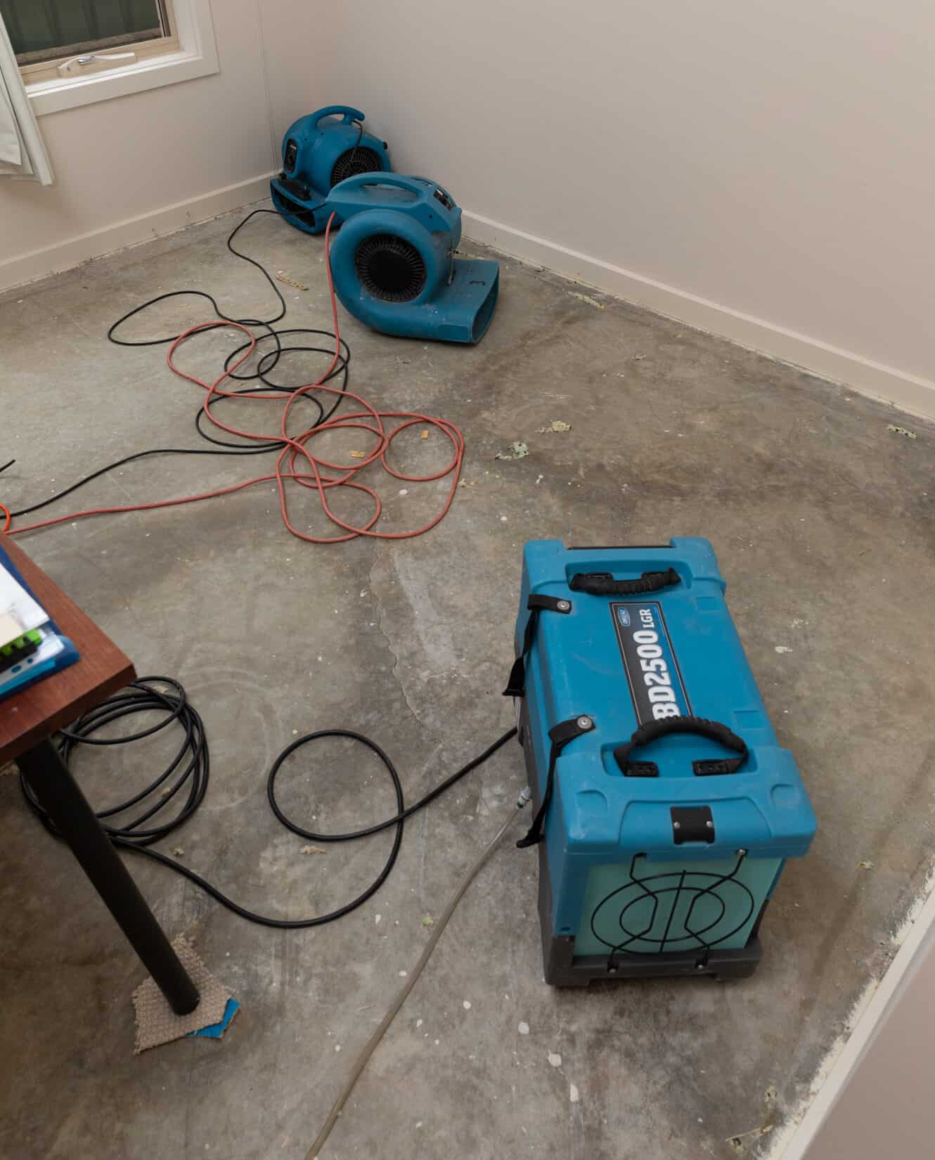 drying fans set up to reduce moisture in flood affected room