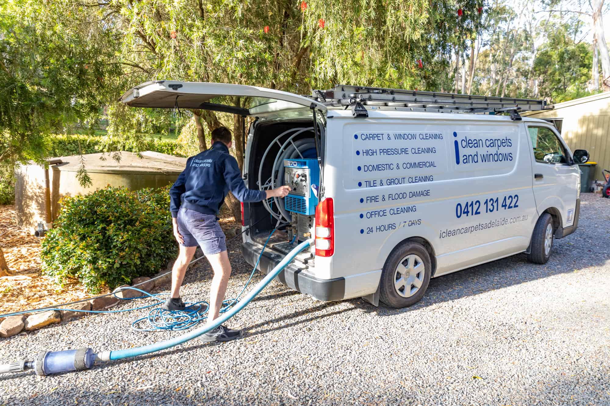 van outside house with worker getting ready for the carpet cleaning job